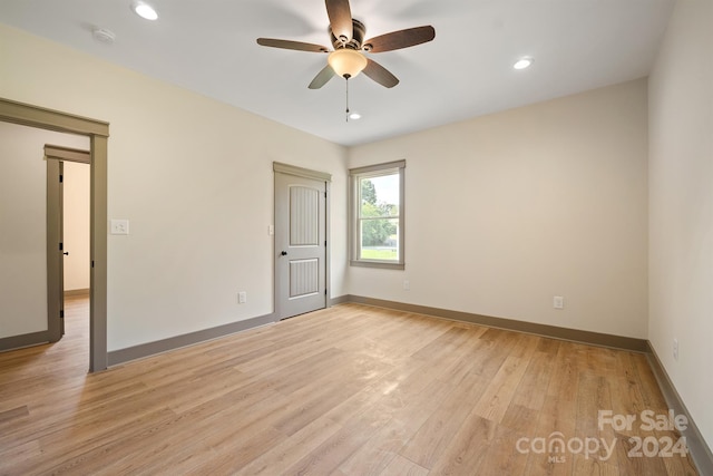 spare room featuring light wood-style flooring, baseboards, and recessed lighting