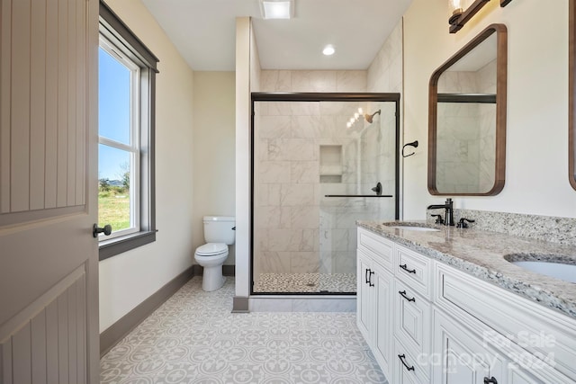 full bath featuring double vanity, a stall shower, a sink, and toilet