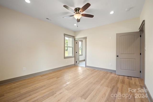 empty room featuring light wood finished floors, recessed lighting, visible vents, and baseboards