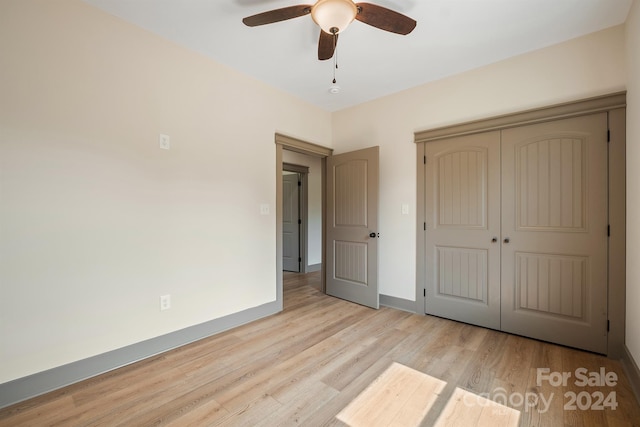 unfurnished bedroom with a ceiling fan, light wood-type flooring, a closet, and baseboards