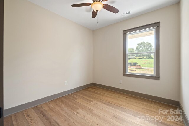 unfurnished room featuring baseboards, ceiling fan, visible vents, and light wood-style floors