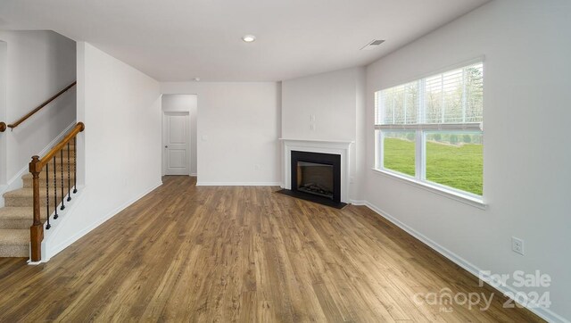 unfurnished living room featuring hardwood / wood-style flooring and a healthy amount of sunlight