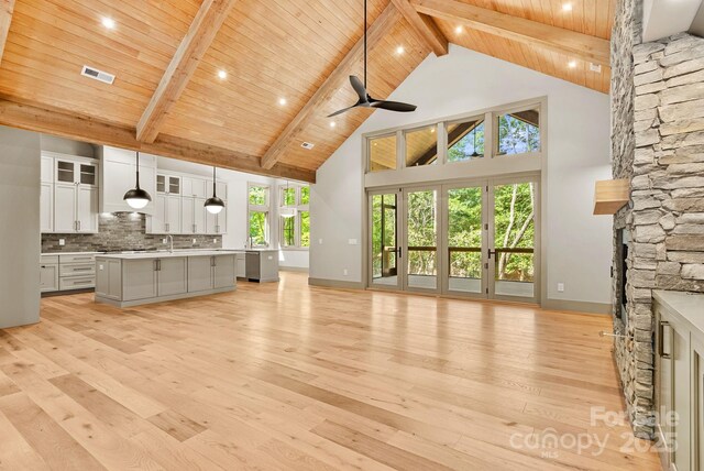 11 Nestlewood Dr Unit 310, Arden, NC 28704 - kitchen with a stone fireplace, open floor plan, a wooden ceiling with exposed beams, high vaulted ceiling, and light wood-style flooring