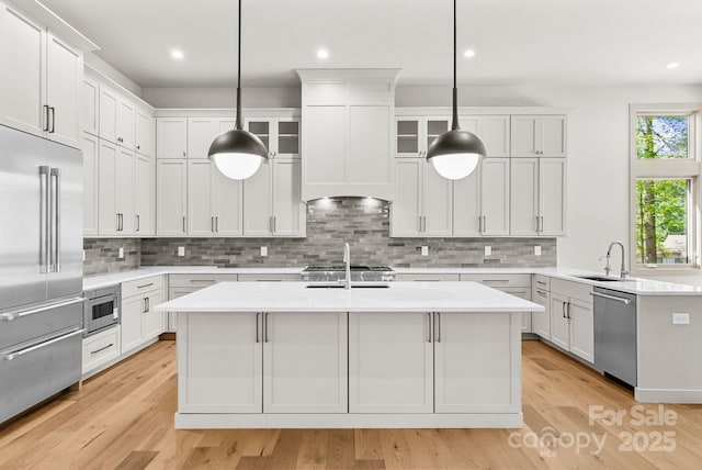 11 Nestlewood Dr Unit 310, Arden, NC 28704 - kitchen with built in appliances, light countertops, a kitchen island with sink, decorative backsplash, and recessed lighting