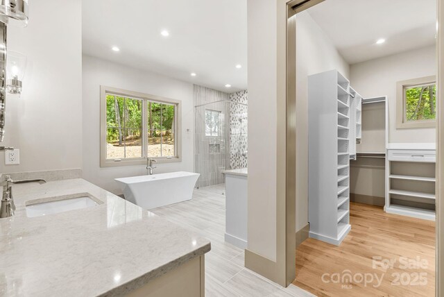 11 Nestlewood Dr Unit 310, Arden, NC 28704 - bathroom featuring a tile shower, a spacious closet, vanity, recessed lighting, and wood finished floors