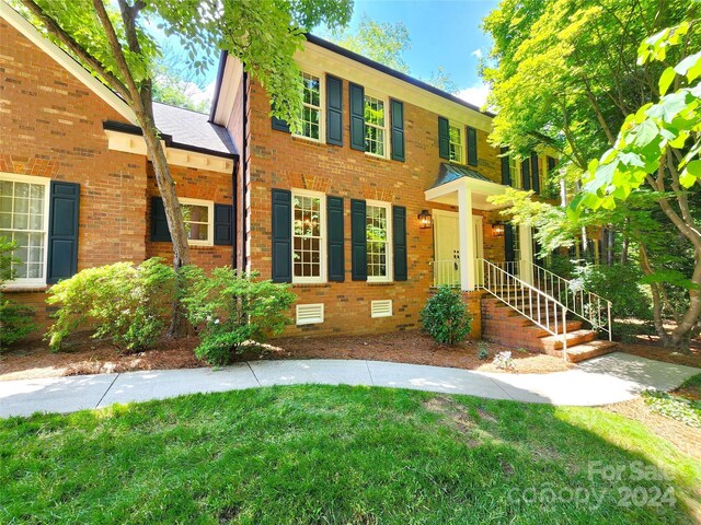 colonial-style house with a front lawn