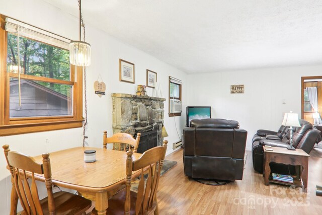 dining room featuring a stone fireplace and light wood-type flooring