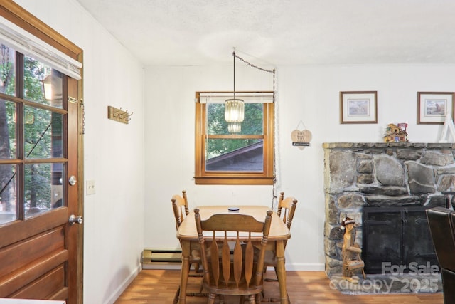 dining space with hardwood / wood-style flooring and a fireplace