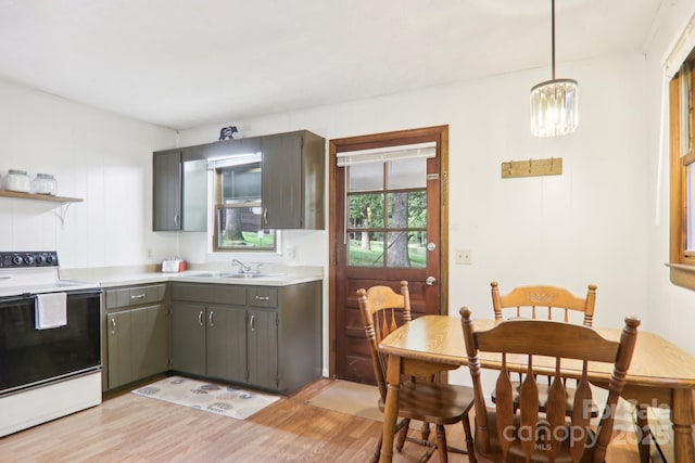 kitchen featuring hanging light fixtures, sink, white electric range, and light hardwood / wood-style flooring