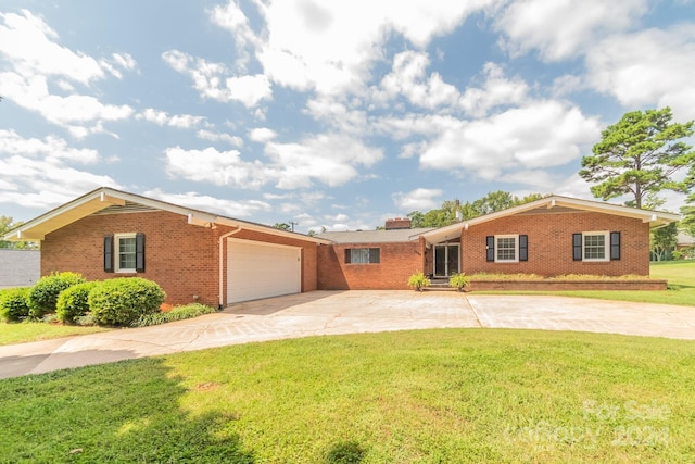 single story home with driveway, a garage, a front lawn, and brick siding