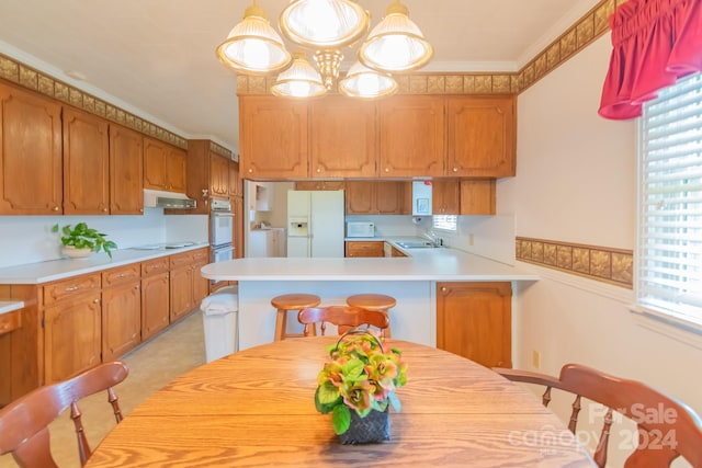 kitchen with kitchen peninsula, plenty of natural light, sink, and white refrigerator with ice dispenser