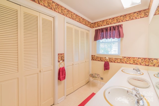 full bathroom featuring a sink, double vanity, ornamental molding, and a closet