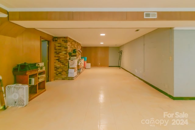 interior space featuring light tile patterned flooring and brick wall