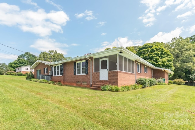 exterior space featuring a front lawn and a sunroom