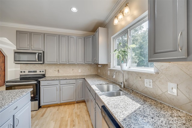 kitchen featuring decorative backsplash, light hardwood / wood-style flooring, stainless steel appliances, and sink