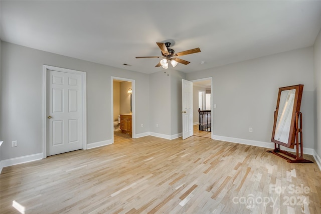 unfurnished bedroom featuring ceiling fan, ensuite bathroom, and light hardwood / wood-style floors