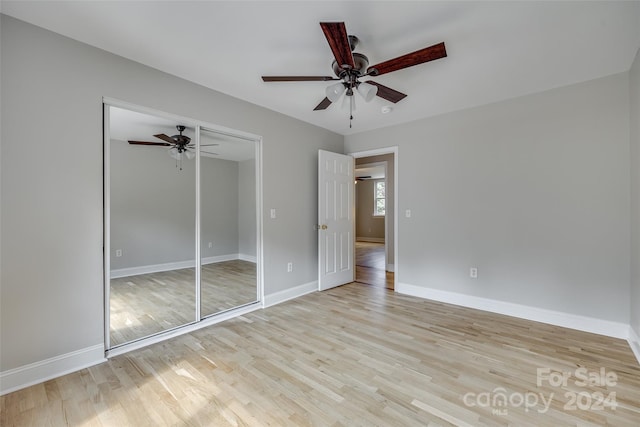 unfurnished bedroom featuring ceiling fan, light wood-type flooring, and a closet