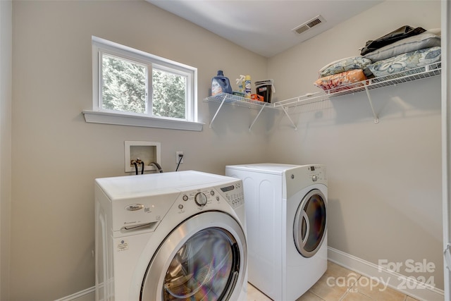 laundry area with light tile patterned flooring and independent washer and dryer