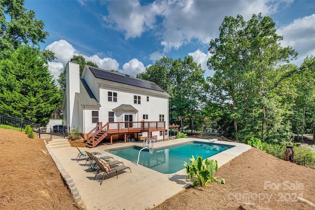 view of pool featuring a diving board, a patio area, and a deck