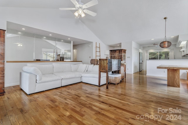 living room with a ceiling fan, light wood-type flooring, high vaulted ceiling, and recessed lighting