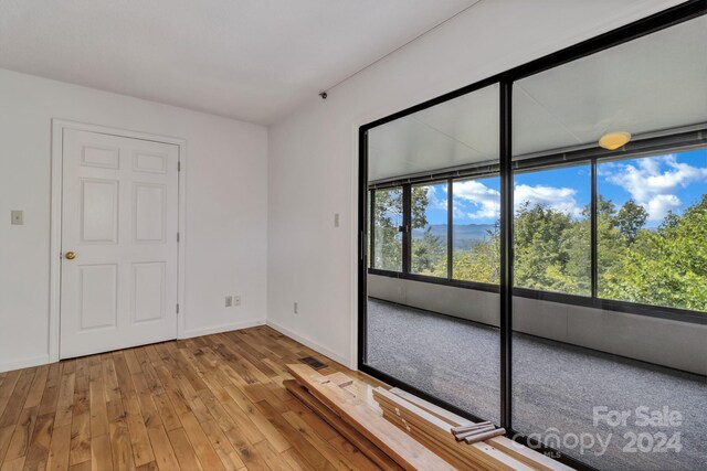 unfurnished room with baseboards and wood finished floors