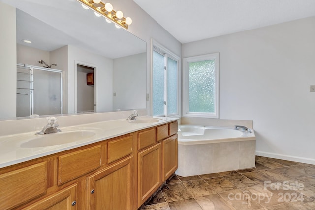 full bathroom featuring a bath, a stall shower, double vanity, and a sink