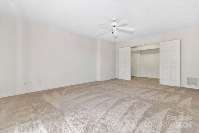 unfurnished bedroom featuring a ceiling fan, a closet, visible vents, and carpet flooring