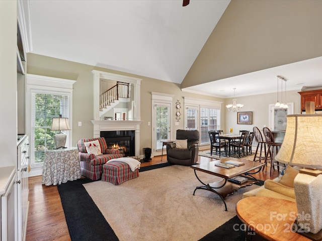 living room featuring a wealth of natural light, dark hardwood / wood-style flooring, vaulted ceiling, and an inviting chandelier