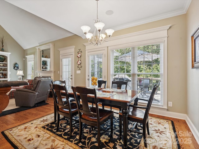 dining space featuring a wealth of natural light, an inviting chandelier, lofted ceiling, and hardwood / wood-style flooring