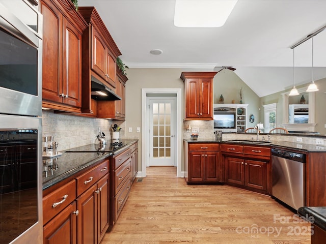 kitchen with decorative light fixtures, sink, appliances with stainless steel finishes, and dark stone counters