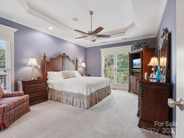 carpeted bedroom featuring a tray ceiling, ceiling fan, and ornamental molding