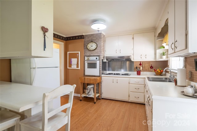 kitchen with white cabinetry, white appliances, light hardwood / wood-style flooring, tasteful backsplash, and sink