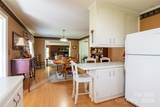 kitchen featuring pendant lighting, white fridge, white cabinetry, light hardwood / wood-style flooring, and kitchen peninsula