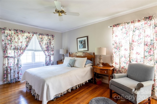 bedroom featuring crown molding, dark wood-type flooring, and ceiling fan