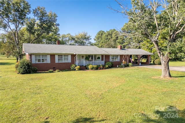 ranch-style house featuring a porch, a carport, and a front yard