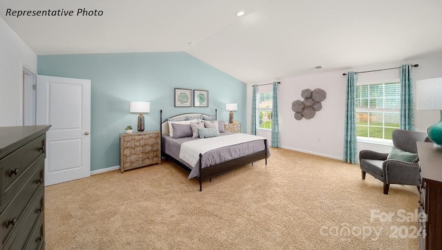 bedroom with lofted ceiling and light carpet