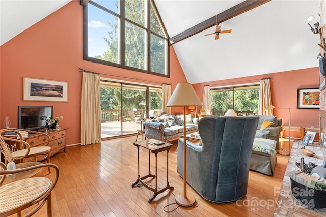 living room with high vaulted ceiling, plenty of natural light, and light hardwood / wood-style floors