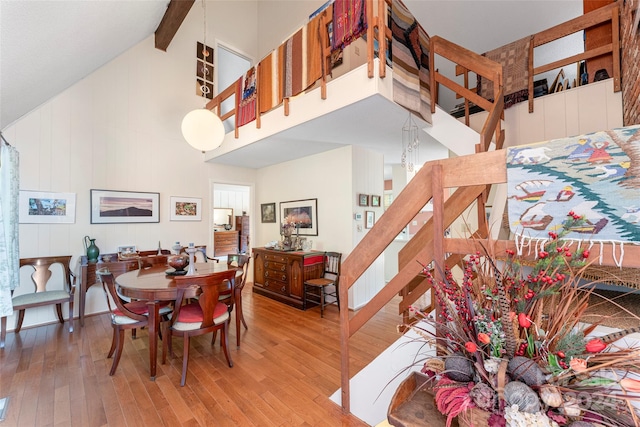 dining room with hardwood / wood-style flooring and high vaulted ceiling