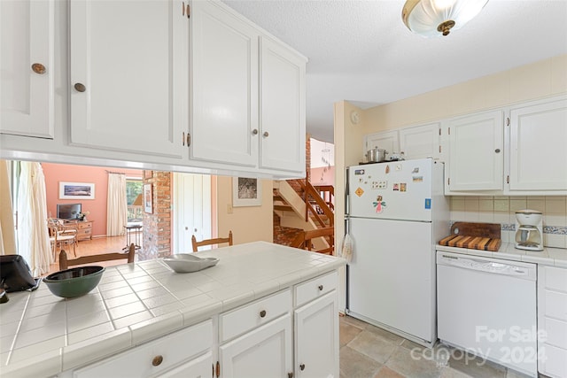 kitchen with backsplash, white appliances, white cabinetry, and tile countertops