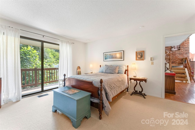 carpeted bedroom featuring a textured ceiling and access to outside