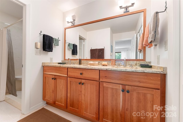 bathroom with dual vanity and tile patterned floors