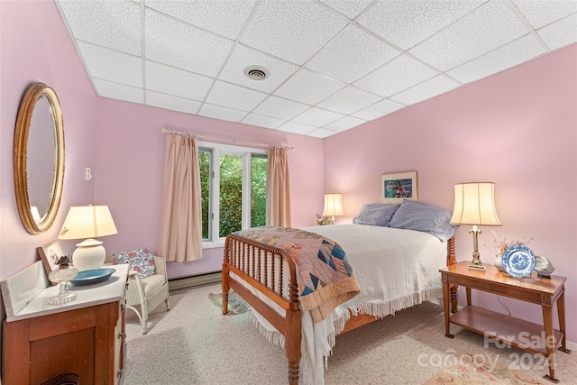 bedroom featuring a drop ceiling and baseboard heating