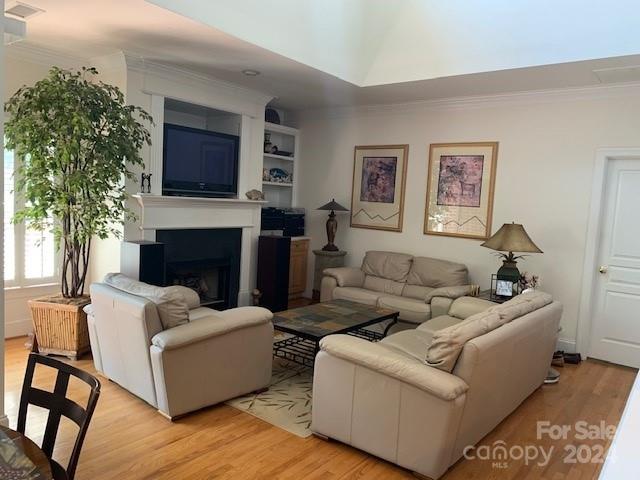 living room featuring light wood-type flooring and crown molding