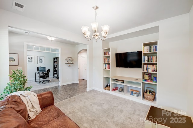 living room with carpet and an inviting chandelier