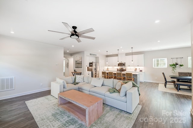 living room featuring light hardwood / wood-style floors and ceiling fan