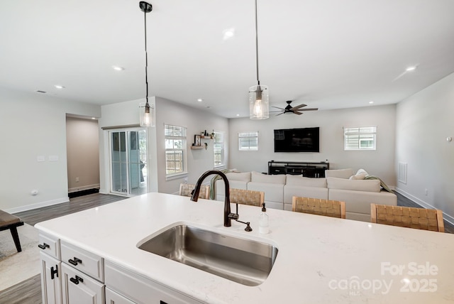 kitchen featuring ceiling fan, dark wood-type flooring, sink, decorative light fixtures, and white cabinets