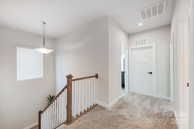 hall featuring light colored carpet