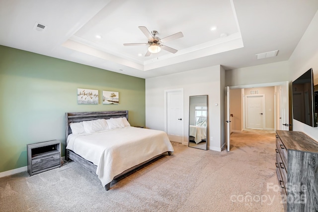 bedroom featuring a tray ceiling, ceiling fan, and light colored carpet