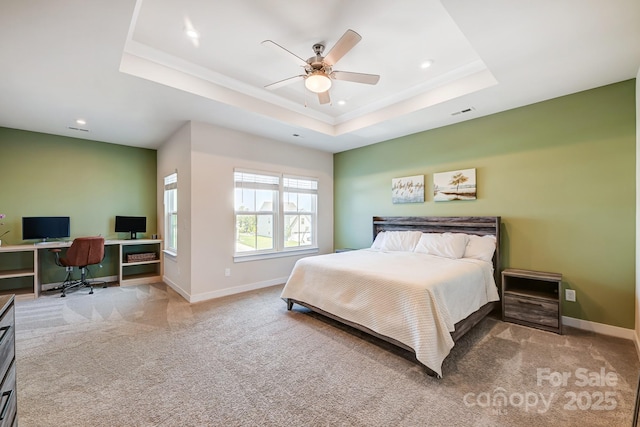 carpeted bedroom featuring a tray ceiling and ceiling fan