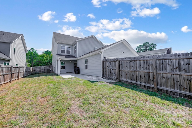 rear view of property featuring a patio area and a yard